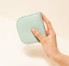 A hand is holding a light blue wallet.