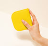 A hand is holding a yellow wallet.
