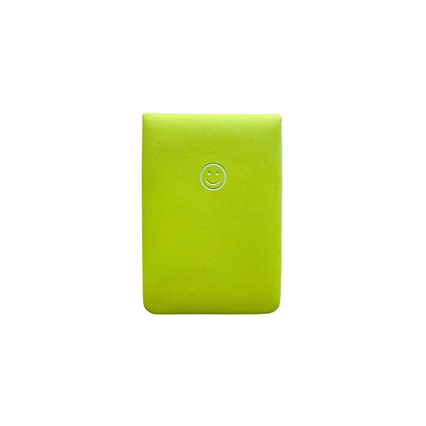 A white background with a lime green notepad in front of it. The notepad features a silver smiley face.