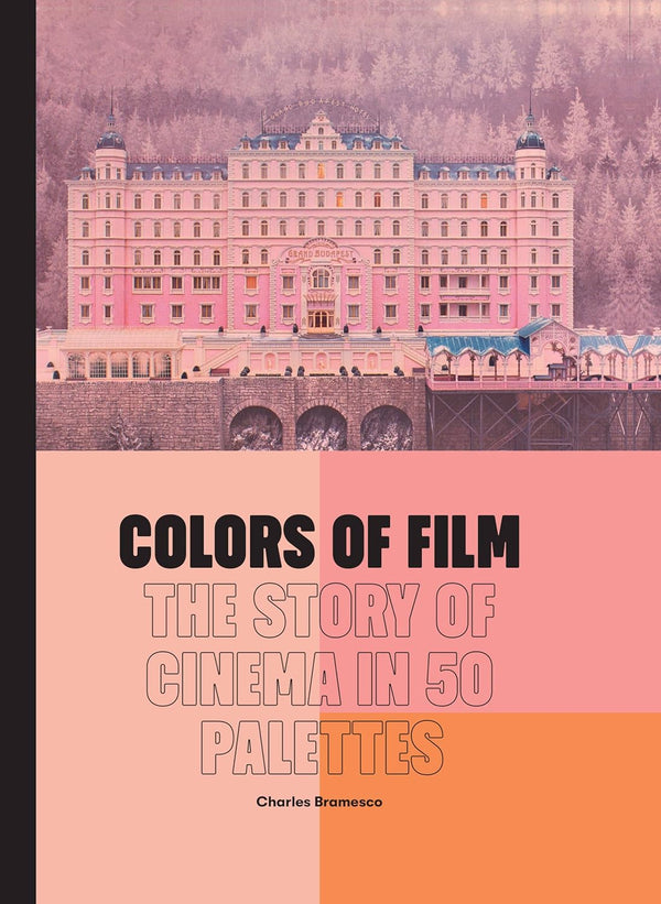 A pink book with a black binding. The book cover has an image of a still from the film "The Grand Budapest Hotel" which features a large pink hotel surrounded by mountainous forest. Below the image are three shades of pink and coral colors making up a geometric palette. The title of the book "Colors of Film: the Story of Cinema in Fifty Palettes" is written in black font.