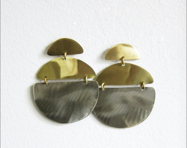 Golden earrings consisting of three different parts attached with tiny rings forming the shape of a circle and a half circle as the stud.