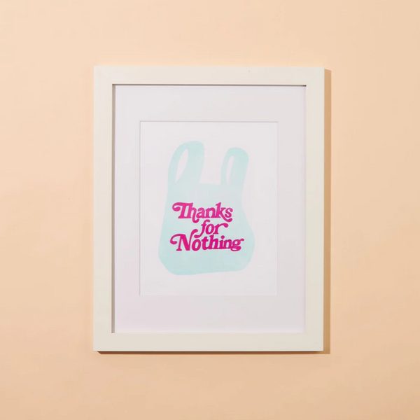A peachy background with a framed print before it. The print features a plastic grocery bag with the words "Thanks for Nothing" on it. 