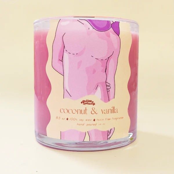 A candle with an illustration of a male body in pink and the text "Coconut & Vanilla Soy Wax Candle.