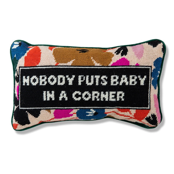 A colorful needlepoint pillow with flowers and the text "Nobody puts baby in the corner."