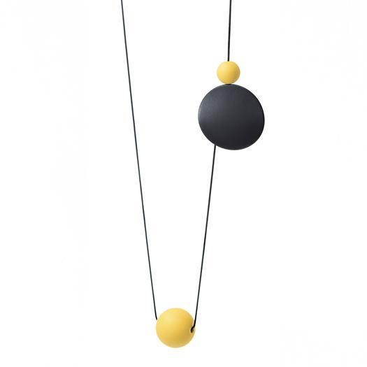 Long necklace with a statement pendant in the shape of three orbs in black and yellow.