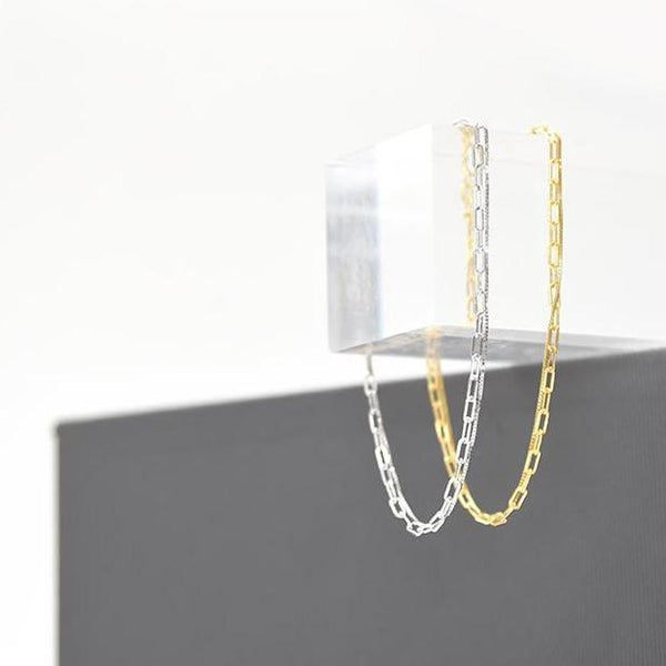 A bracelet made up of two intertwined sterling chains in silver and gold; one linked and one smooth.