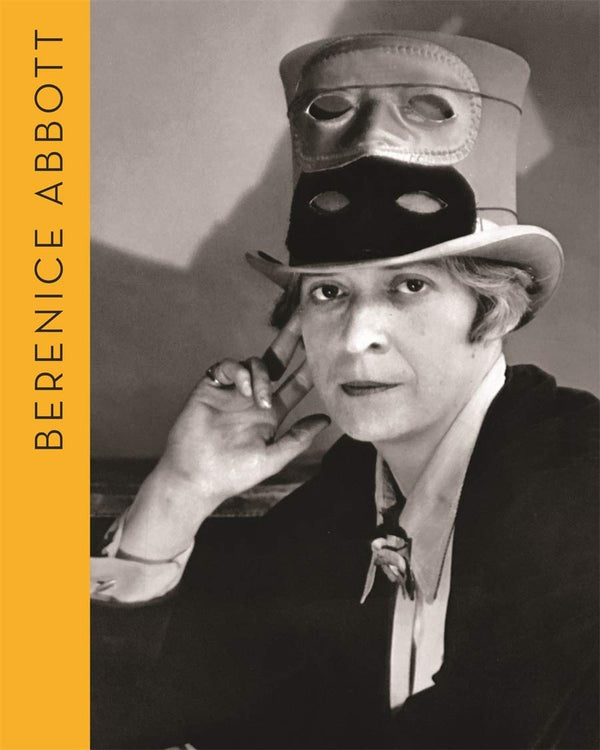 A book cover featuring a black and white photograph of a woman wearing a top hat with two masks on top. The title reads "Berenice Abbott."