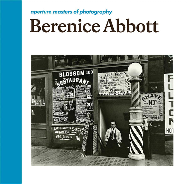 A white book cover with a black and white photograph of a storefront. The title reads "Berenice Abbott: Aperture Masters of Photography."
