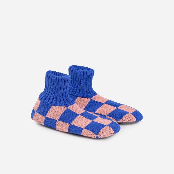 A pair of knit fleece-lined slippers with a checkerboard pattern in pink and blue.