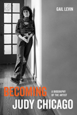 A book cover with a black and white photograph of a woman standing by a wall. The title reads "Becoming Judy Chicago."