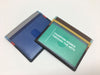 Two colorful leather credit card holders with four slots each. One holds a business card.