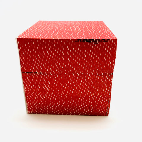 Red note cube with sticky notes with a dot pattern all over. 