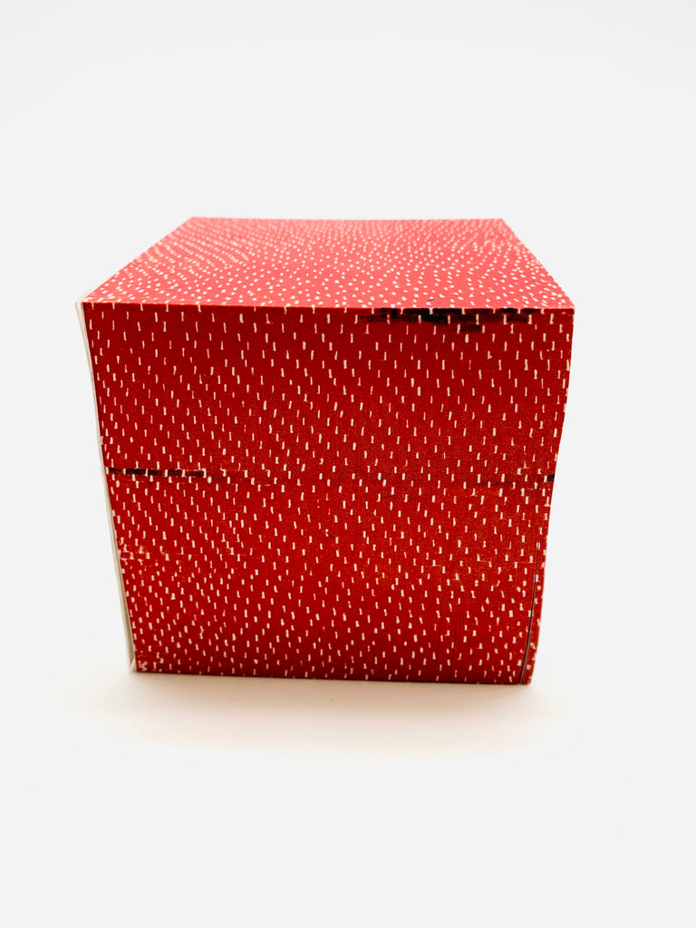 Red note cube with sticky notes with a dot pattern all over.