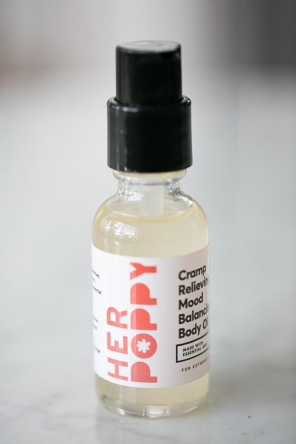 A small glass bottle a white label reading "Cramp Relieving, Mood Balancing Body Oil."