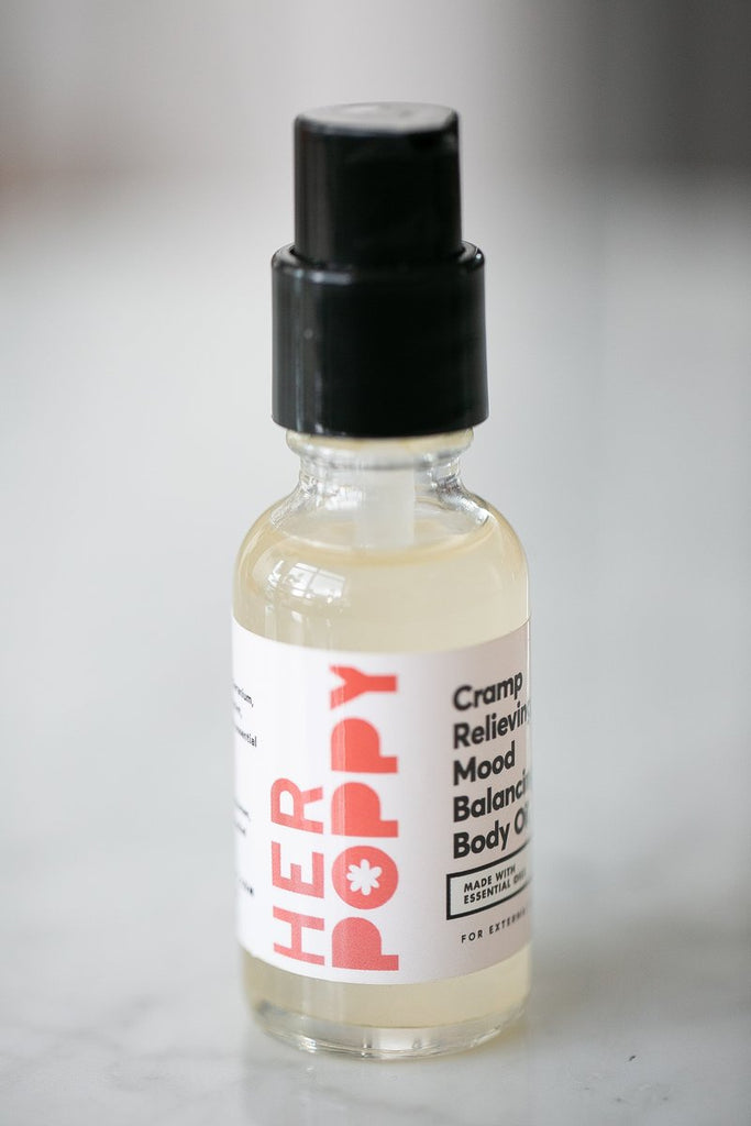 A small glass bottle a white label reading "Cramp Relieving, Mood Balancing Body Oil."