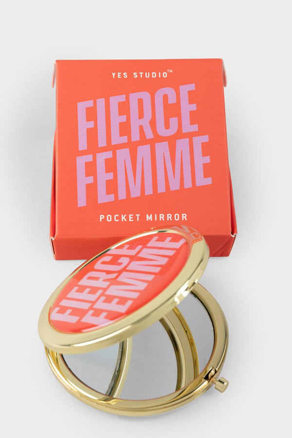 A golden pocket mirror with a red cover and text in pink reading "Fierce Femme." A red box with a pink text reading "Fierce Femme."