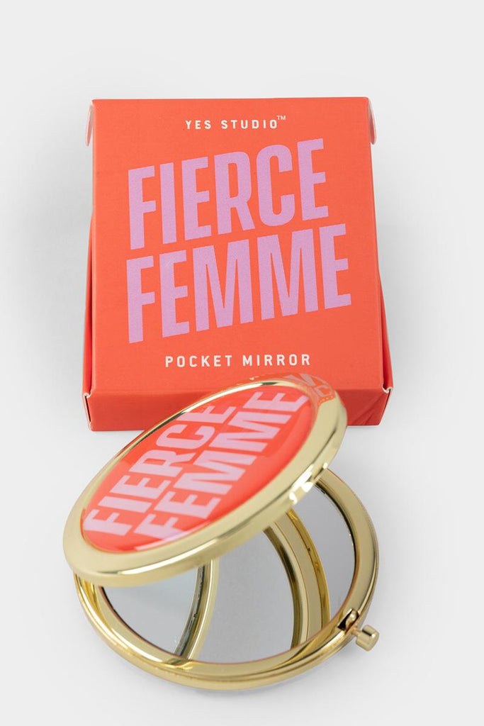 A golden pocket mirror with a red cover and text in pink reading "Fierce Femme." A red box with a pink text reading "Fierce Femme."