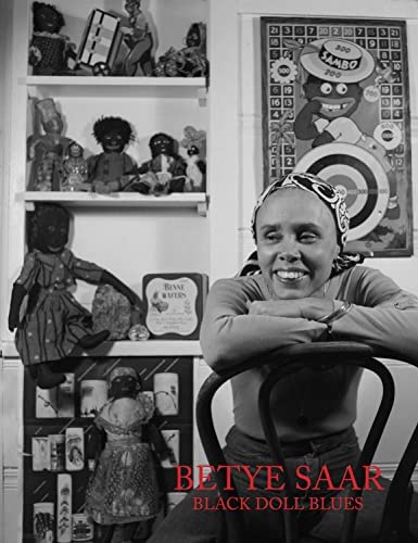 Book cover featuring a photograph of a woman with a medium-dark skin tone sitting on a chair leaning on its back and smiling. Several dolls with dark skin tones are sat behind her on a wall shelf. The title reads "Betye Saar. Black Doll Blues."
