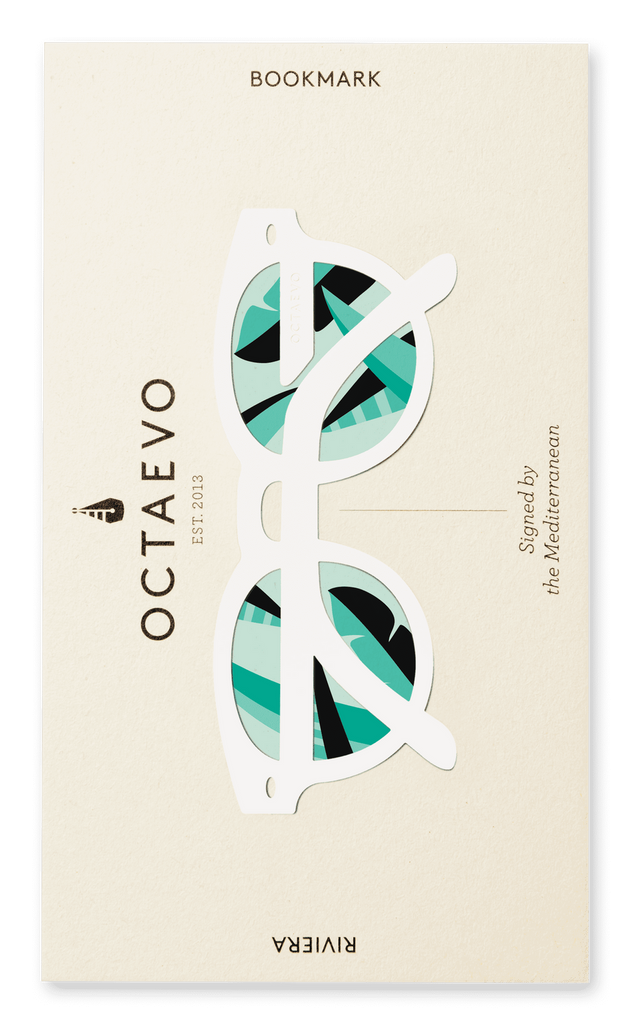 A bookmark in the shape of glasses with a thick, white frame, in white packaging with the text "Octaveo" and "Bookmark Riviera White."