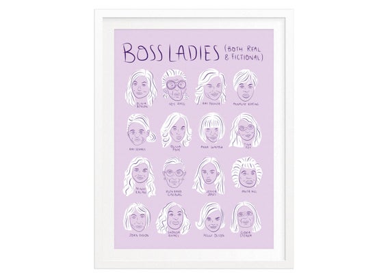 A lilac print in a white frame with illustrations of women's heads and the text "Boss Ladies."