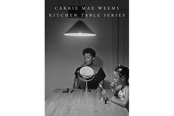 A book cover with a black-and-white photograph of a woman with a dark skin tone and a little girl sitting by a table doing their make-up. The title reads "Carrie Mae Weems: Kitchen Table Series."