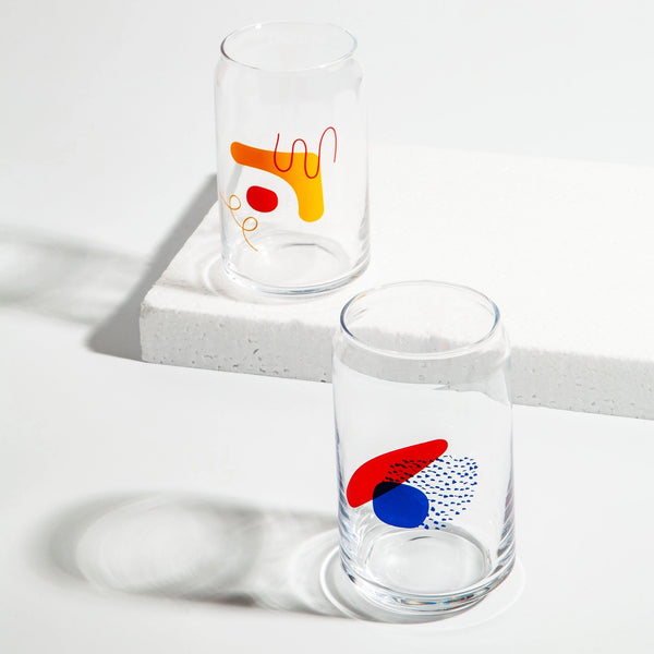 Two drinking glasses with colorful abstract shapes in red, orange, and blue.
