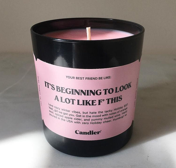 Candle with a pink sticker and the text "It's beginning to look a lot like F this."