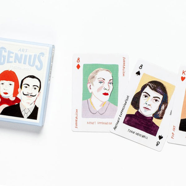 Card game box featuring a man with a mustache and a woman with red hair and dress with polka dots. The title reads "Art Genius Playing Cards." Several cards from the game with faces of women are lying next to the box.