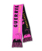 The pink and black scarf is in the style of a soccer scarf with an illustration of a person in a gorilla mask holding up their fist and text in pink and yellow.