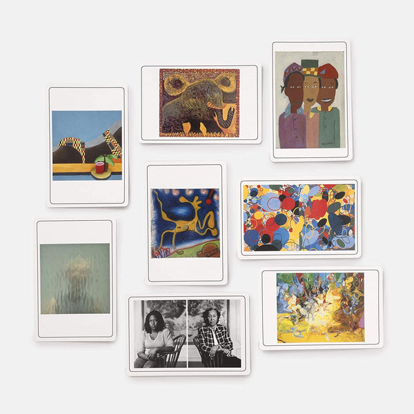 A variety of white cards with colorful paintings and photographs.