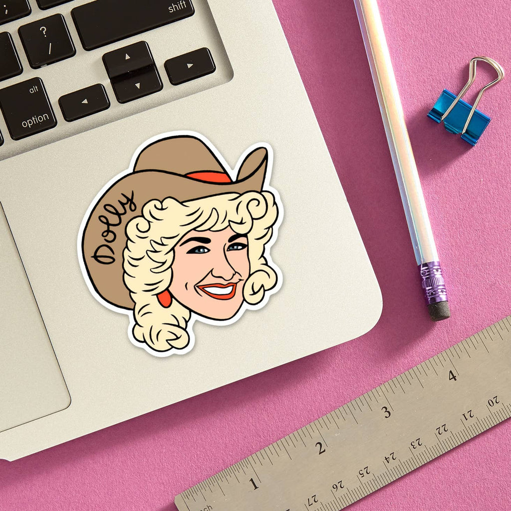 A sticker of a woman's head on a lapotp. The woman has a light skin tone, blonde hair, and is wearing a cowboy hat. On her hat, it says "Dolly."