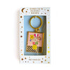 Keychain with floral design in a Carolyn Suzuki Goods packaging on a white background.