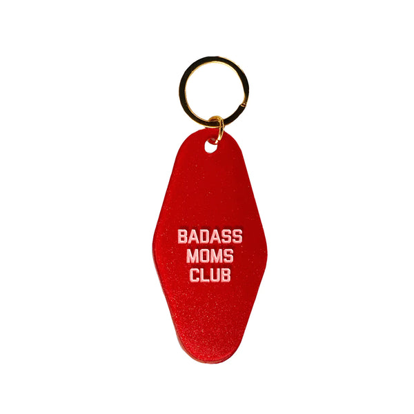 A red key tag with white text reading "Badass Moms Club."