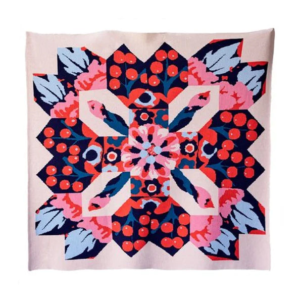 A colorful wool blanket with a floral abstract pattern resembling a quilting pattern.
