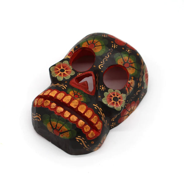 Hand-carved and hand-painted wooden mask of a skull with flowers painted on it.