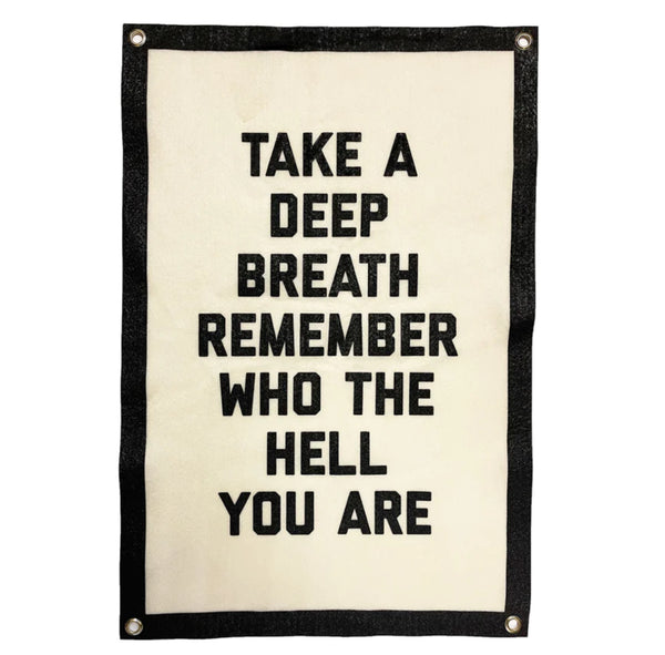 A wool banner in black and white with the text "Take a deep breath remember who the hell you are."