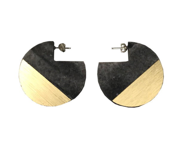 A pair of earrings in black and gold in a round shape with a silver stud.