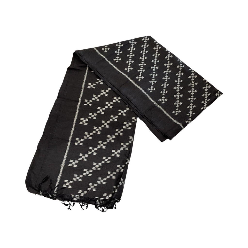 A black scarf with a white border three inches from the hem. Within the border are rows of squares that form a diagonal pattern across the scarf. 