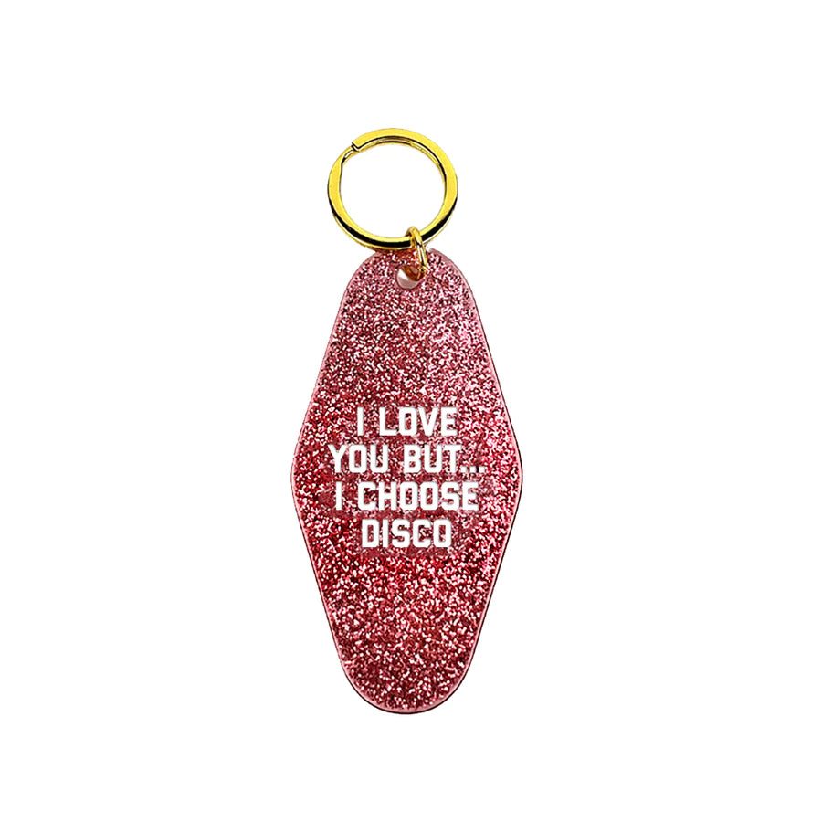 A white background with a sparkly pink keytag in front of it. The keytag reads "I Love You But...I Choose Disco." 