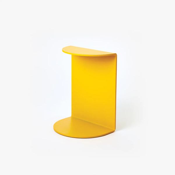 A white background with a bookend before it. The bookend is yellow with a curved flap on the top and bottom.