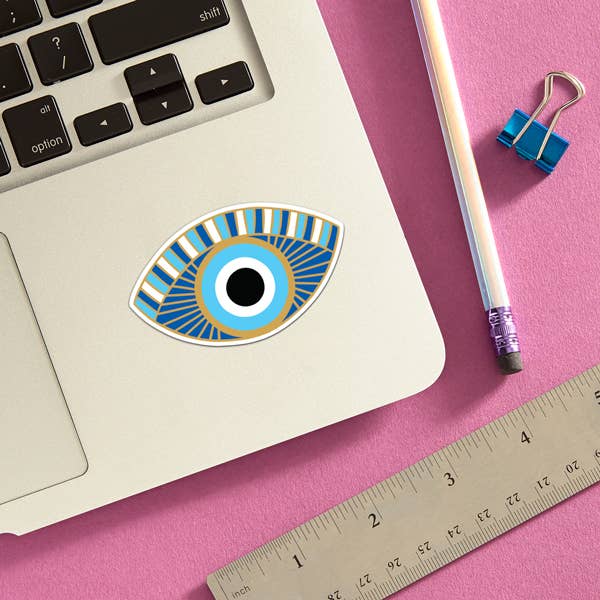 Sticker of a blue eye attached to a laptop.