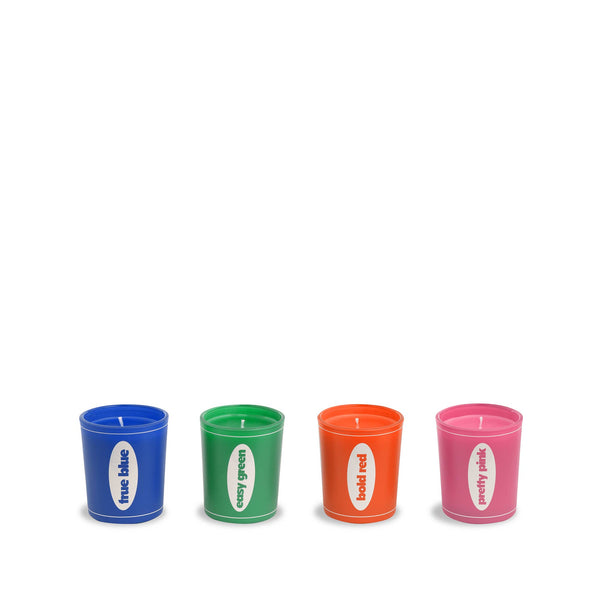 Four candles in bold colors standing next to each other. Each candle says its color, including "true blue", "cosy green", "bold red", and "pretty pink."