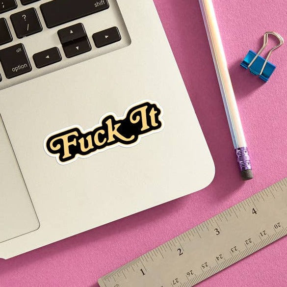 A sticker with the text "Fuck it" on a laptop.
