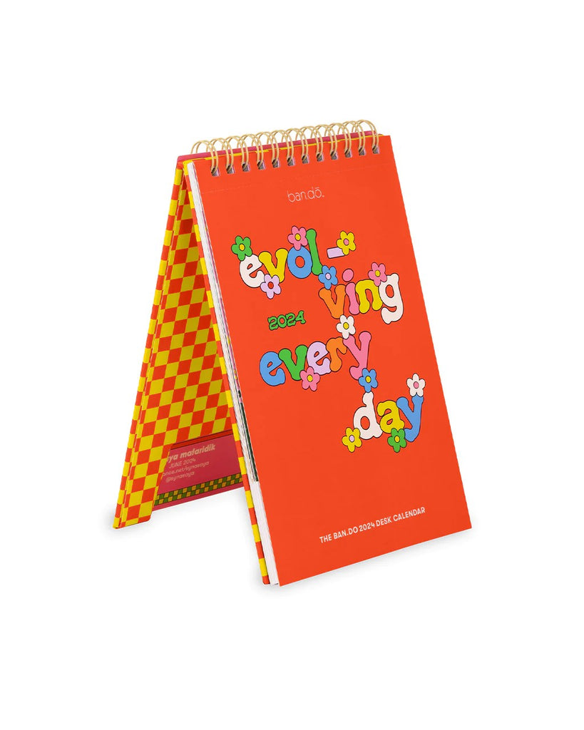 Orange calendar with colorful text and flowers around the text. The text reads "ever-evolving every day."