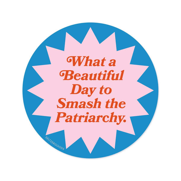 A round sticker in blue and pink with text in red, reading "What a beautiful day to smash the patriarchy."