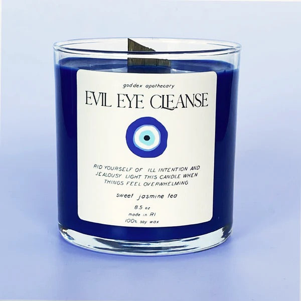 Blue candle with text reading "Evil Eye Cleanse: Sweet Jasmine Tea Soy Candle."