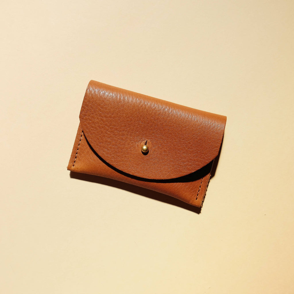 Brown leather wallet on a beige background