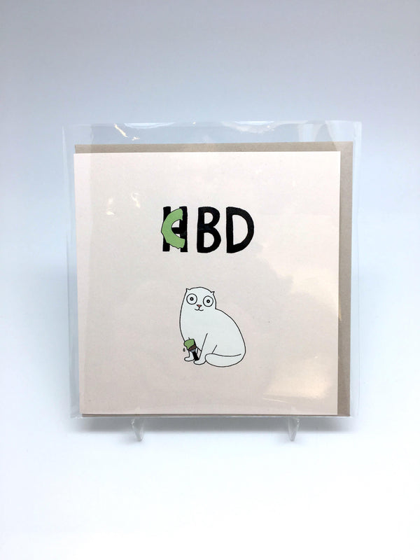 A greeting card with an illustration of a white cat holding a green paint brush and the text "CBD."