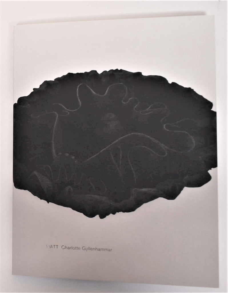 A white book cover with a black organic ceramic object and silver linings within it. The title reads "Charlotte Gyllenhammar: NATT."
