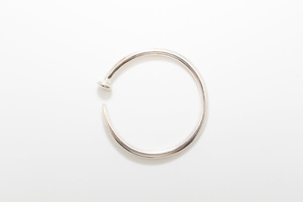 A silver plated metal bracelet before a white background.